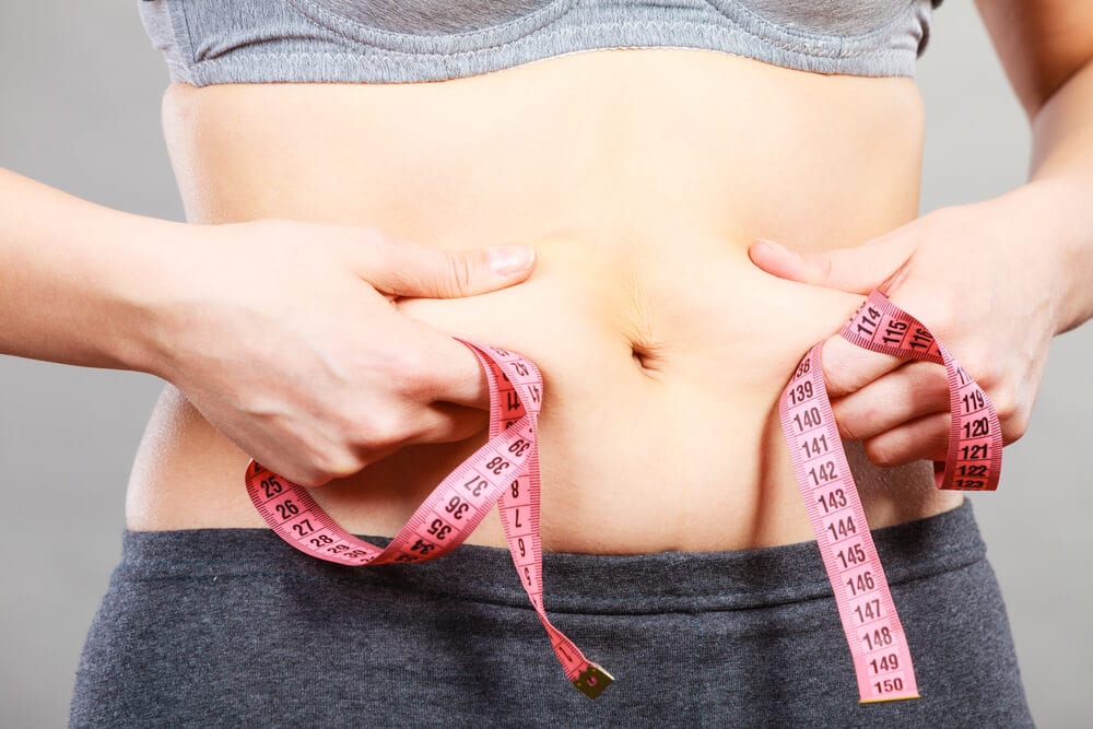 woman pulling on tough stomach skin
